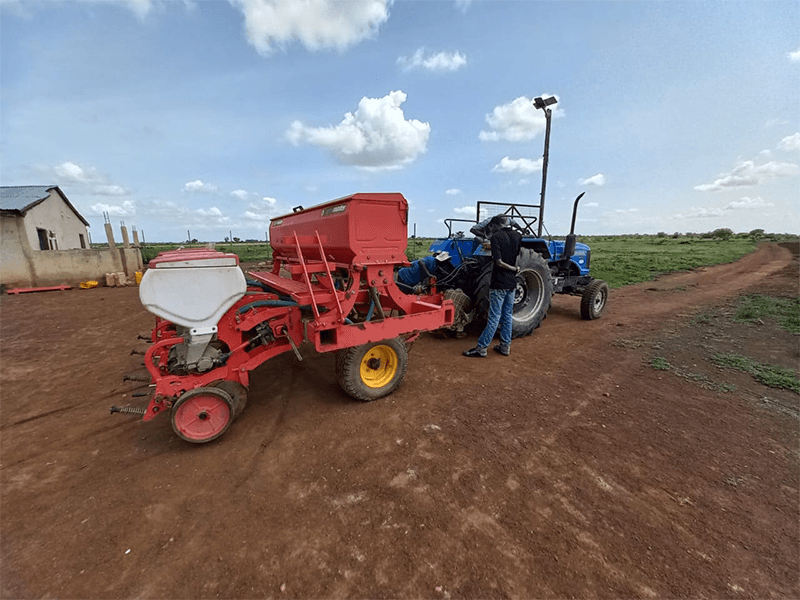 Mechanized planter at work under clear skies